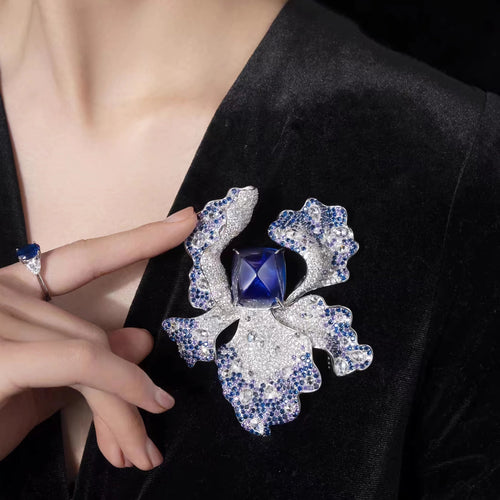 lady wearing  Blue sapphire brooch with fancy color pavé