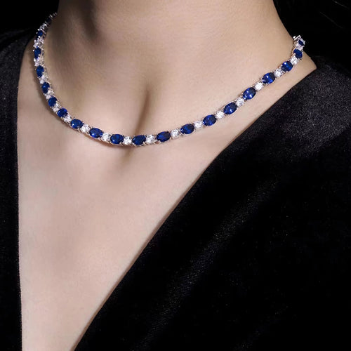 Lady wearing alternating blue sapphire and white zircon necklace