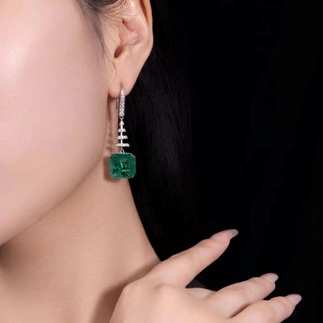 lady wearing Dangling emerald drop earrings in silver