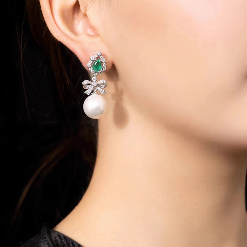 lady wearing Created pearl drop earrings with emerald in silver