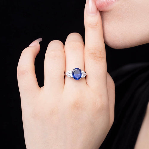 lady wearing blue sapphire ring with moissanites