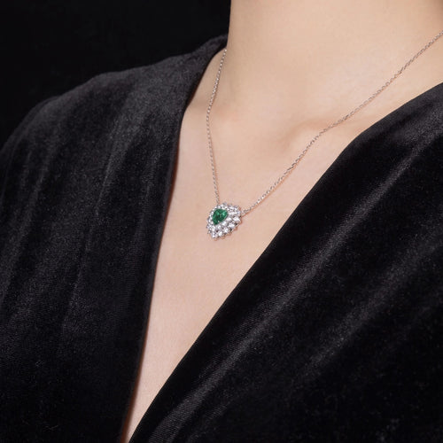 lady wearing Heart cut emerald necklace with halo in silver