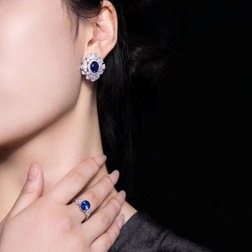 Lady wearing Blue sapphire silver earrings with moissanite halo