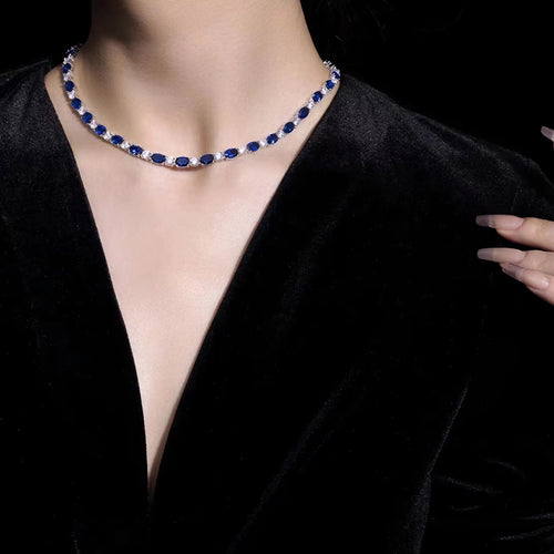 Lady wearing alternating blue sapphire and white zircon necklace