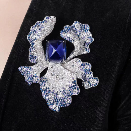 lady wearing Blue sapphire brooch with fancy color pavé