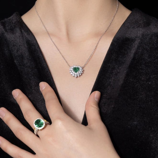 lady wearing Heart cut emerald necklace with halo in silver